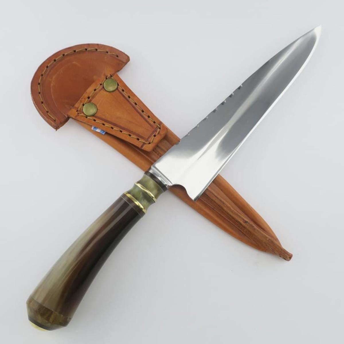 A 7.1-inch stainless steel knife with a polished blade and a unique gradient handle made from cow horn, featuring brass and green stone accents, resting in a light brown leather sheath.