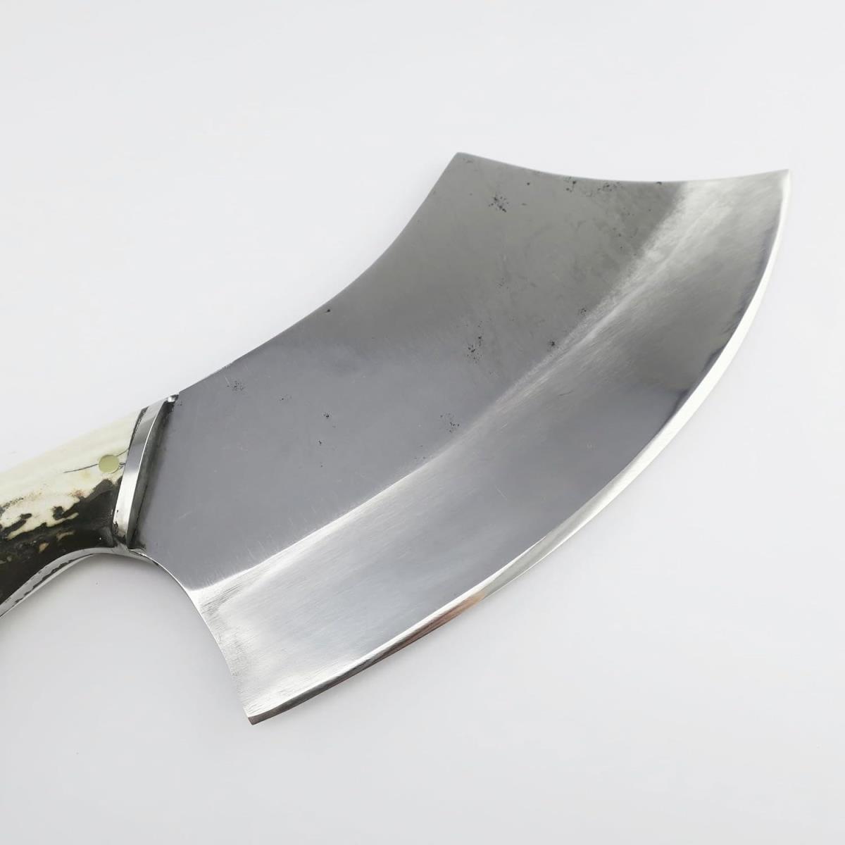 Primer plano de un hacha de acero negro de 7.68 pulgadas con un mango único de asta de ciervo, mostrando la hoja curvada y el diseño rústico. Ideal para coleccionistas y amantes del aire libre.