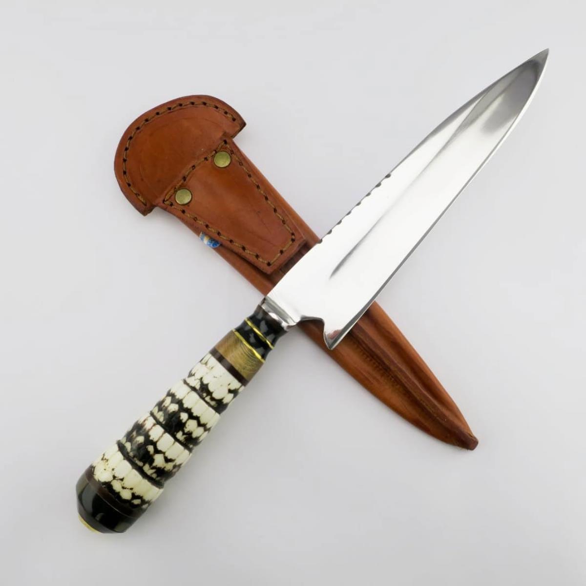 Cuchillo artesanal de 18 cm con hoja de acero inoxidable y mango de cola de armadillo, presentado junto a su funda de cuero marrón sobre un fondo blanco.
