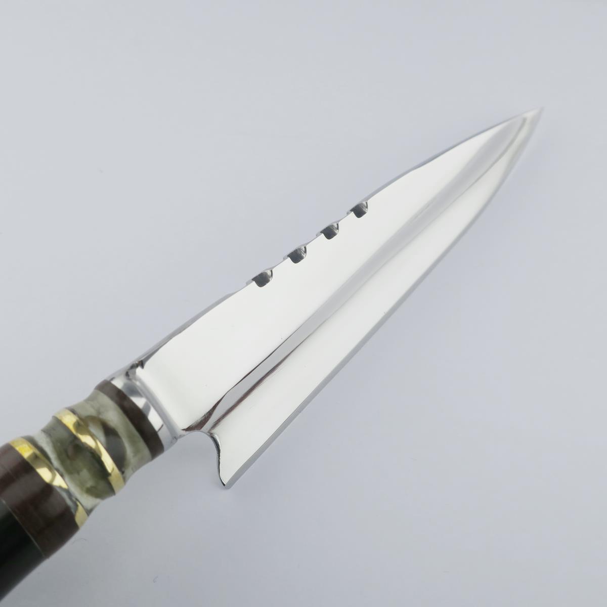 Primer plano de un cuchillo Cow 5.5in Oscuro de acero inoxidable, mostrando su hoja pulida con serraciones únicas y un mango decorativo hecho de segmentos claros y oscuros con anillos dorados.