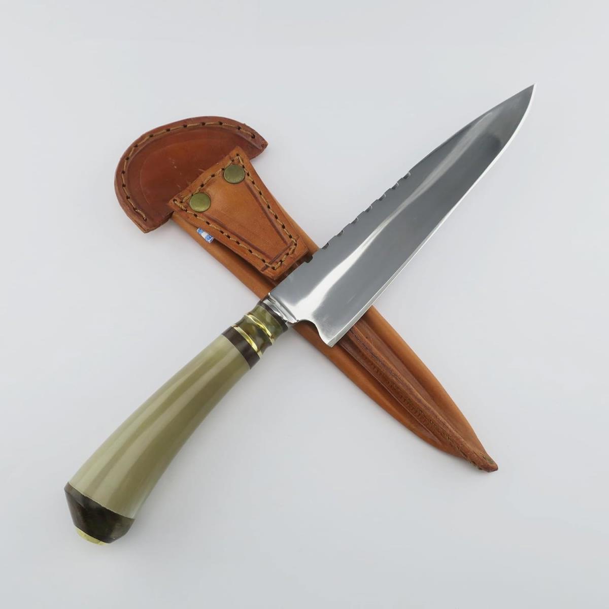 A 7.1-inch stainless steel knife with a polished blade and a unique light cow horn handle, with brass and green stone details, resting in a light brown leather sheath.