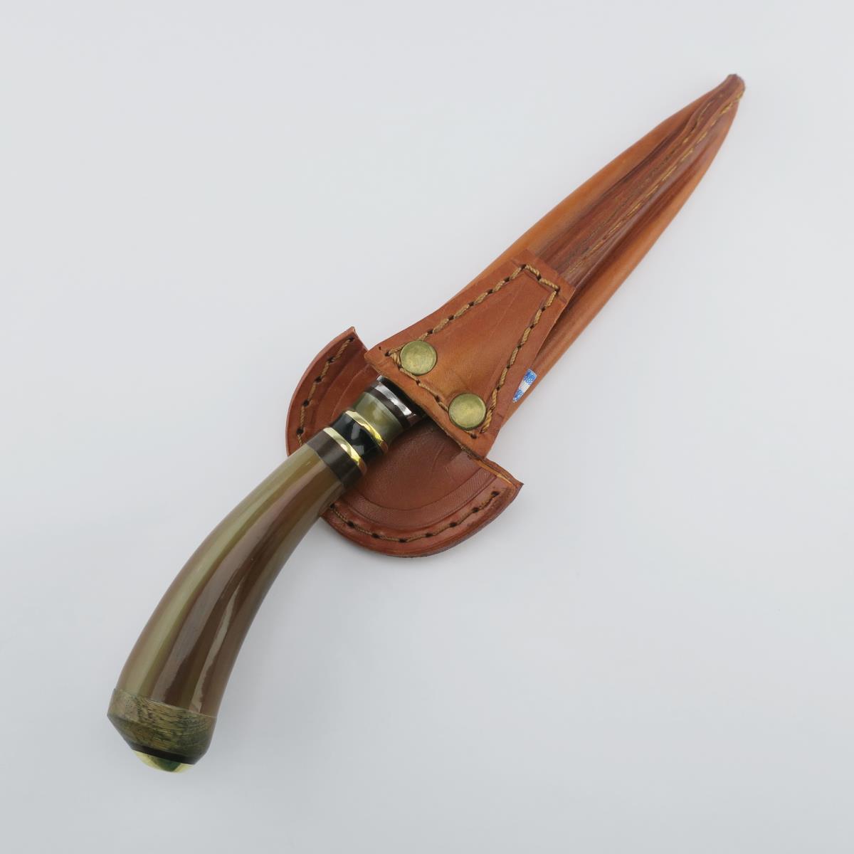 A Cow 5.5in Combined stainless steel knife with a polished horn handle and brass accents, resting in a custom-fit brown leather sheath with brass snap closures. Ideal for collectors and everyday use.